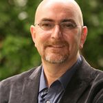 Author smiling for his profile headshot photo